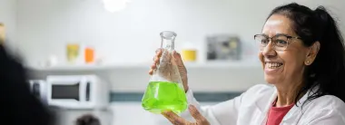 Gender and Diversity in Research, woman smiling and holding scientific flask