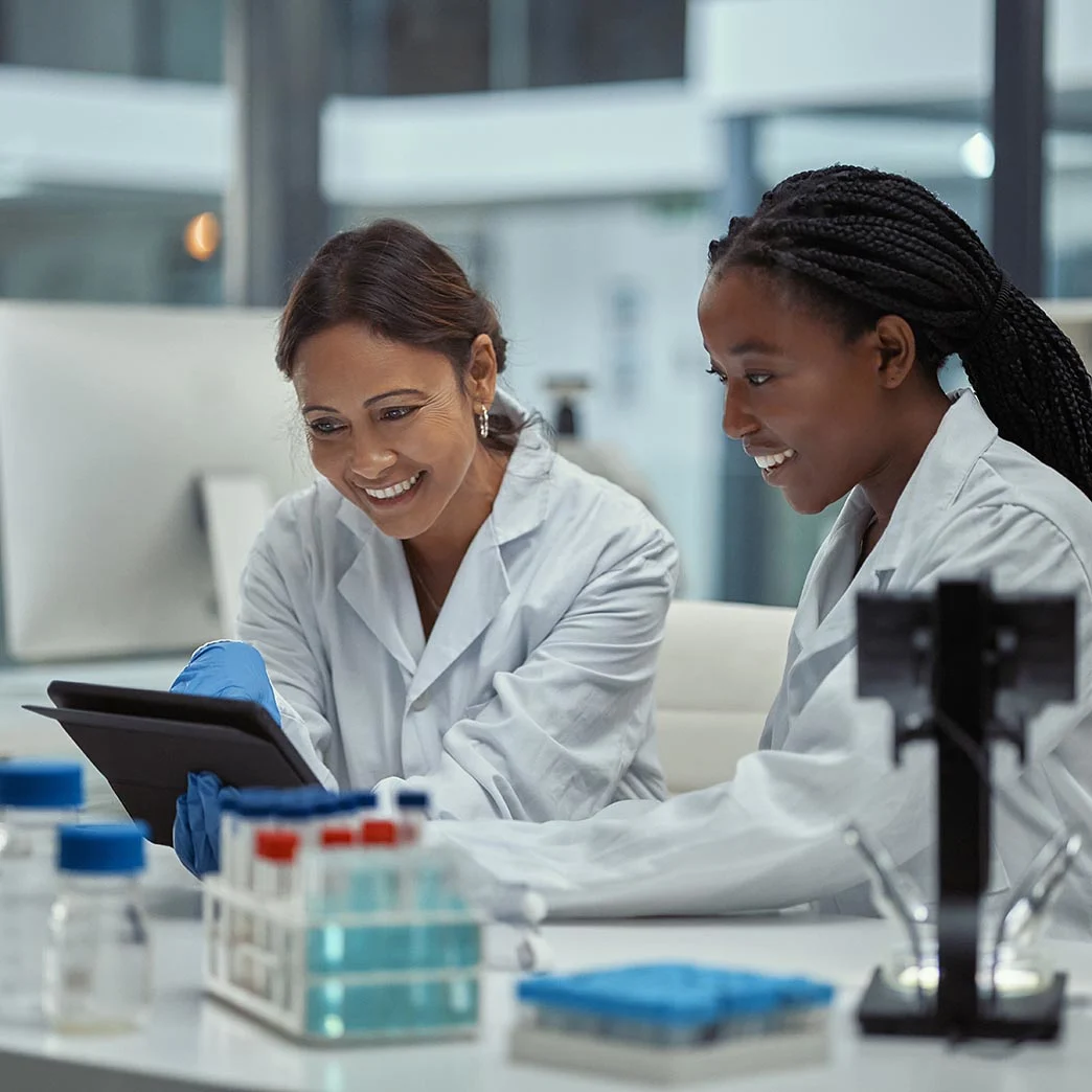 Two scientists collaborating with tablet in lab