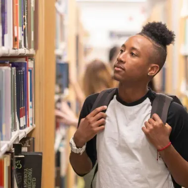 students in library, looking at books