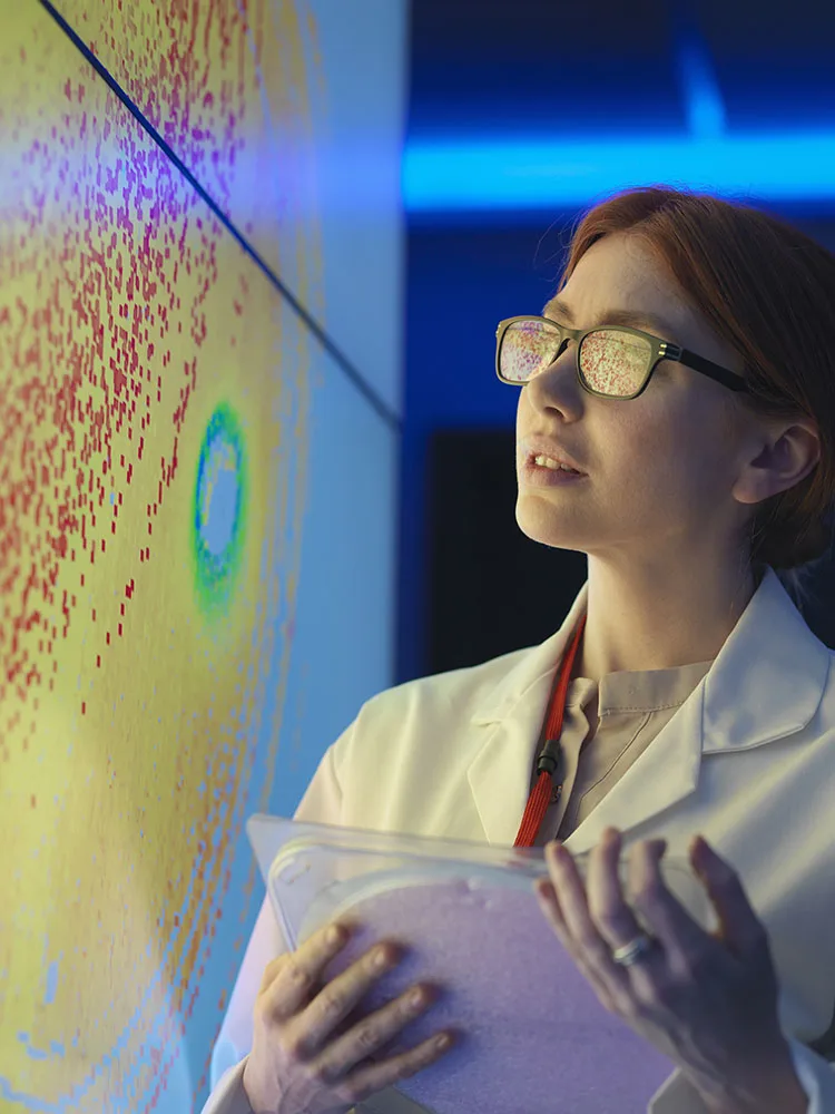 Researcher looking at image on screen and holding device